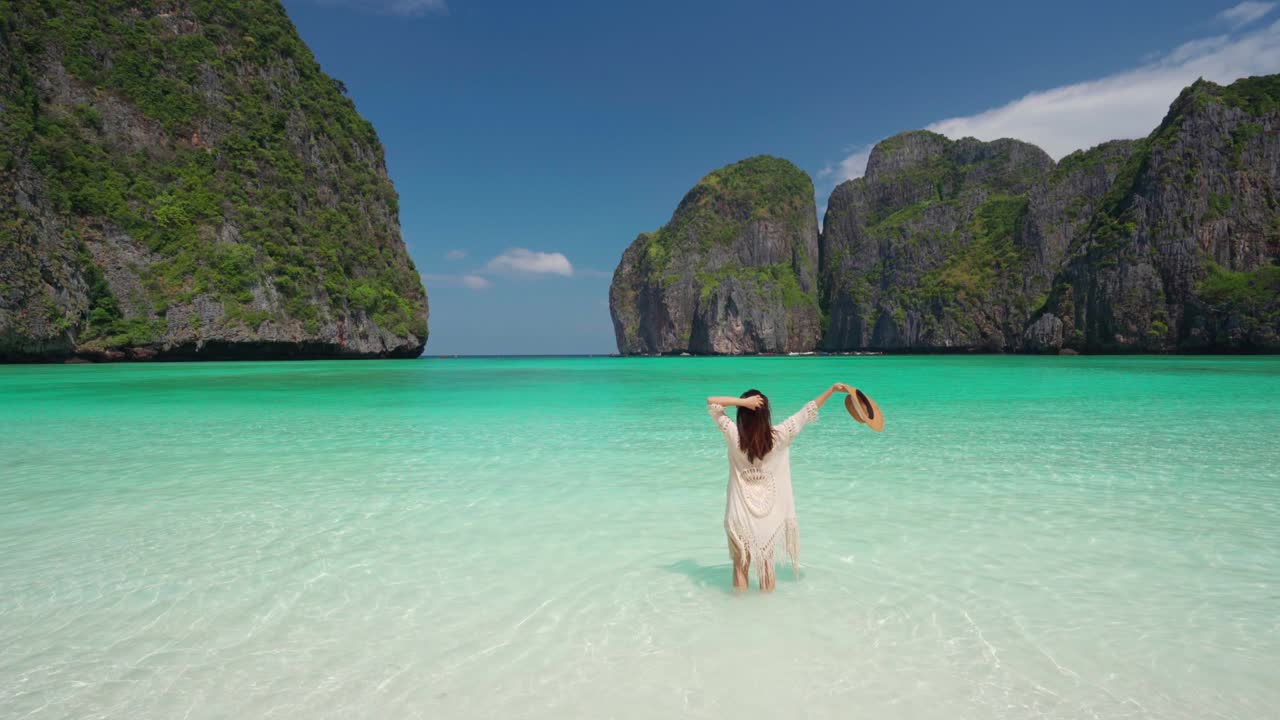 Young woman traveler relaxing and enjoying at beautiful tropical white sand beach at Maya bay in Krabi, Thailand, Summer vacation and Travel concept