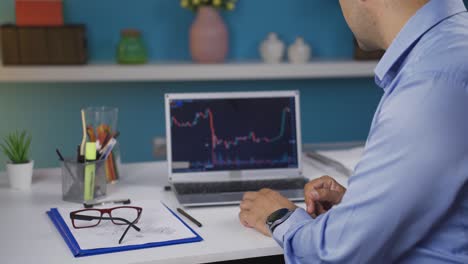 el inversor mira el gráfico del mercado de valores, aplaude cuando gana.