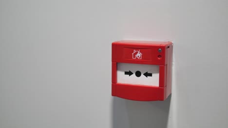 alarma de incendio roja en una pared blanca