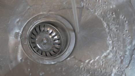 running tap water flowing down plug hole or drain