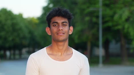 young male fashion model with white shirt posing outdoors