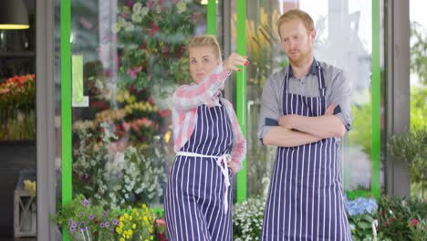 coworkers with tablet near floral shop