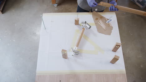 overhead shot of male craftsman in workshop assembling hand built sustainable bamboo bicycle frame