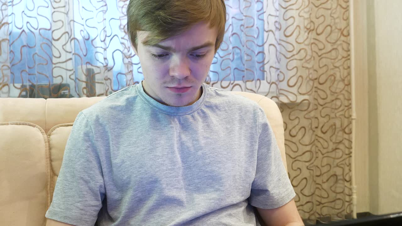 подросток работает на ноутбуке дома