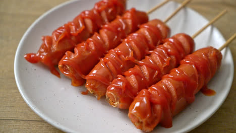 fried sausage skewer with ketchup on white plate