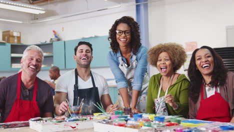 portrait of mature adults attending art class in community centre with teacher