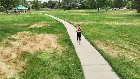 muscular and toned woman runs in a public park demonstrating an inspiring lifestyle for fitness and wellbeing