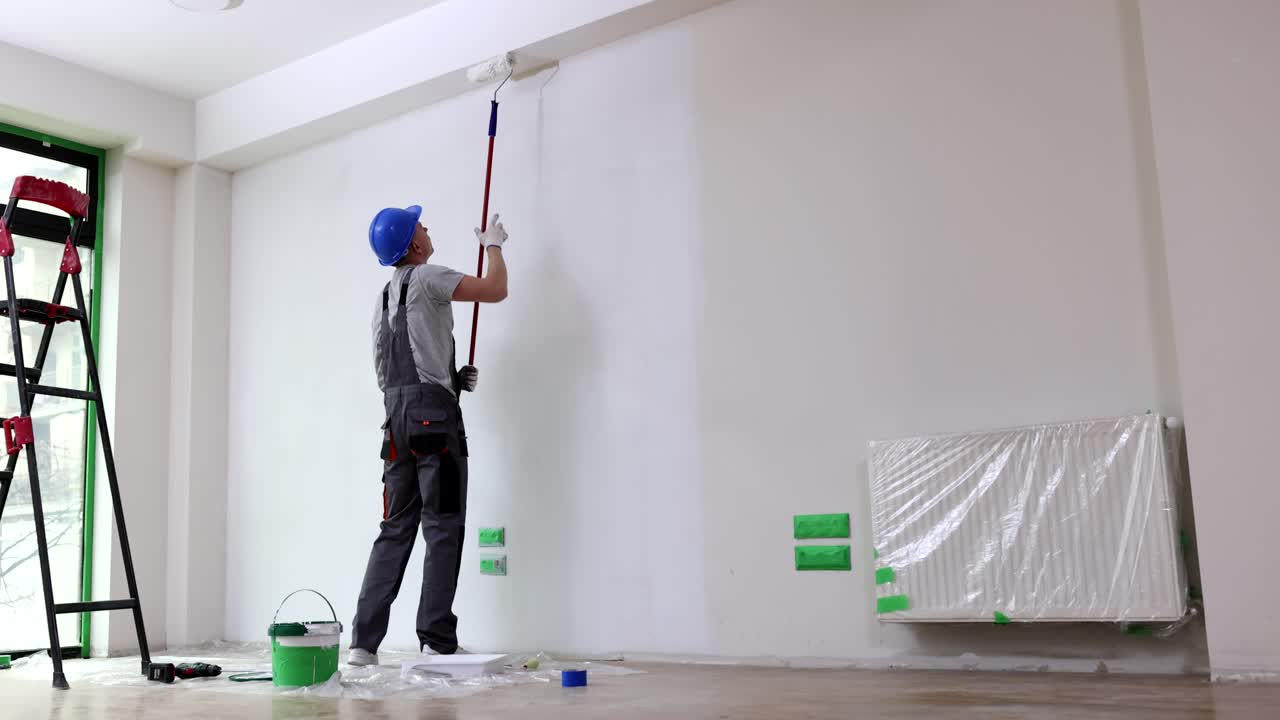 Painter painting a wall indoors