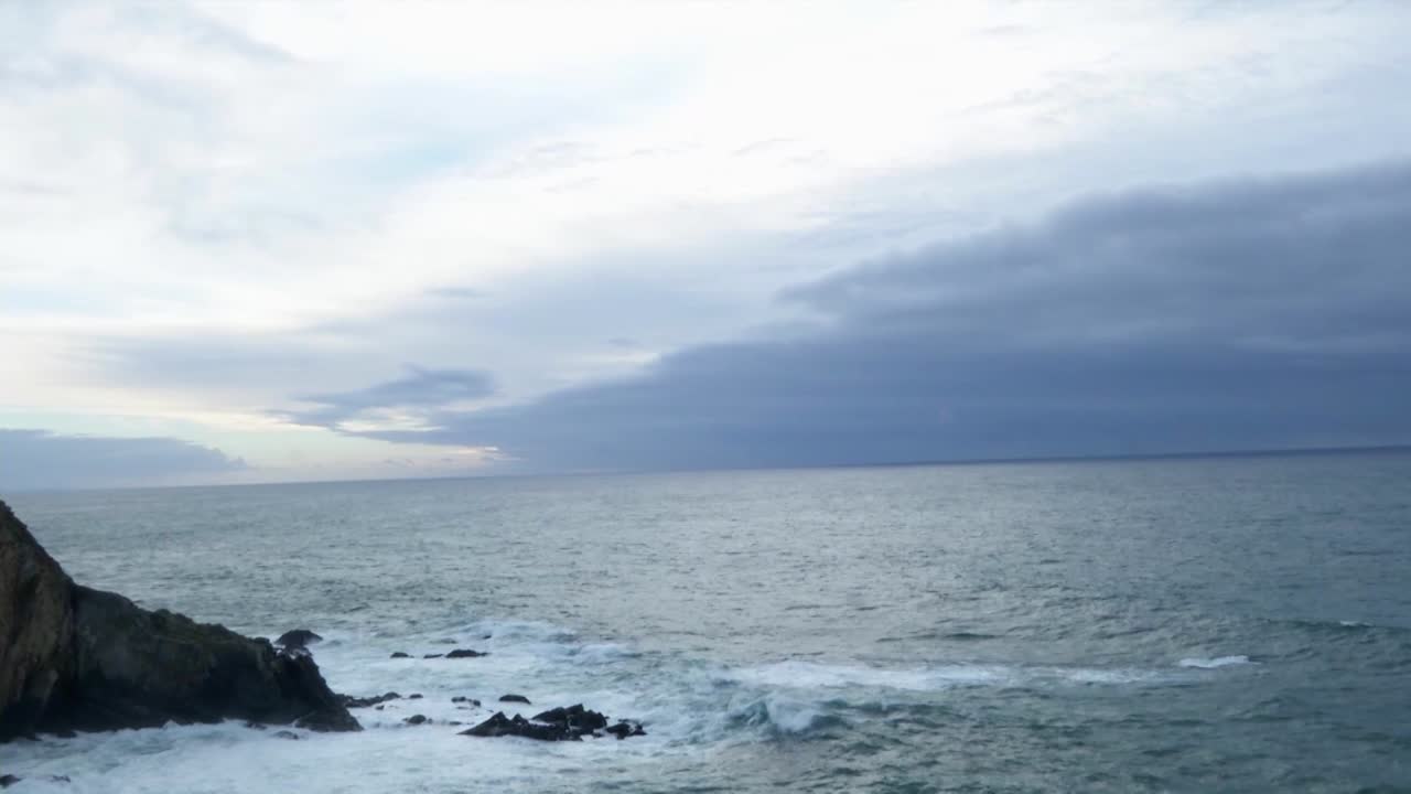 long shot timelapse of the atlantic ocean from the portuguese coast with some cliffrocks and the sky on a cloudy day
