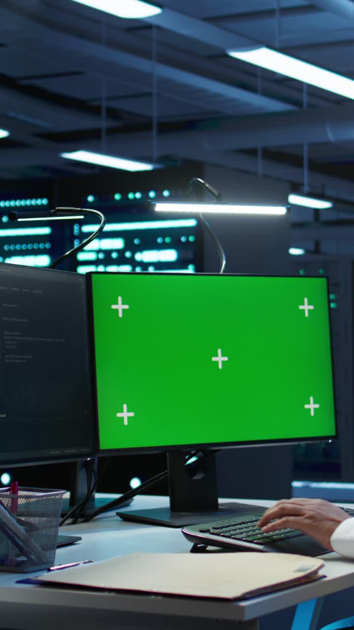 Person, der skriver på tastatur med grøn skærm i datacenter