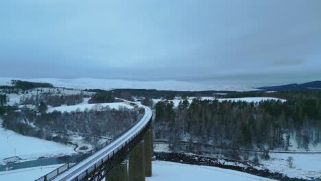 aerial shot of historic single track rail bridge over valley with river