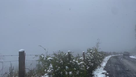 POV-Aufnahme-Aus-Dem-Auto,-Das-Durch-Schneesturm-Entlang-Der-Bergstraße-Fährt,-Wintersturm