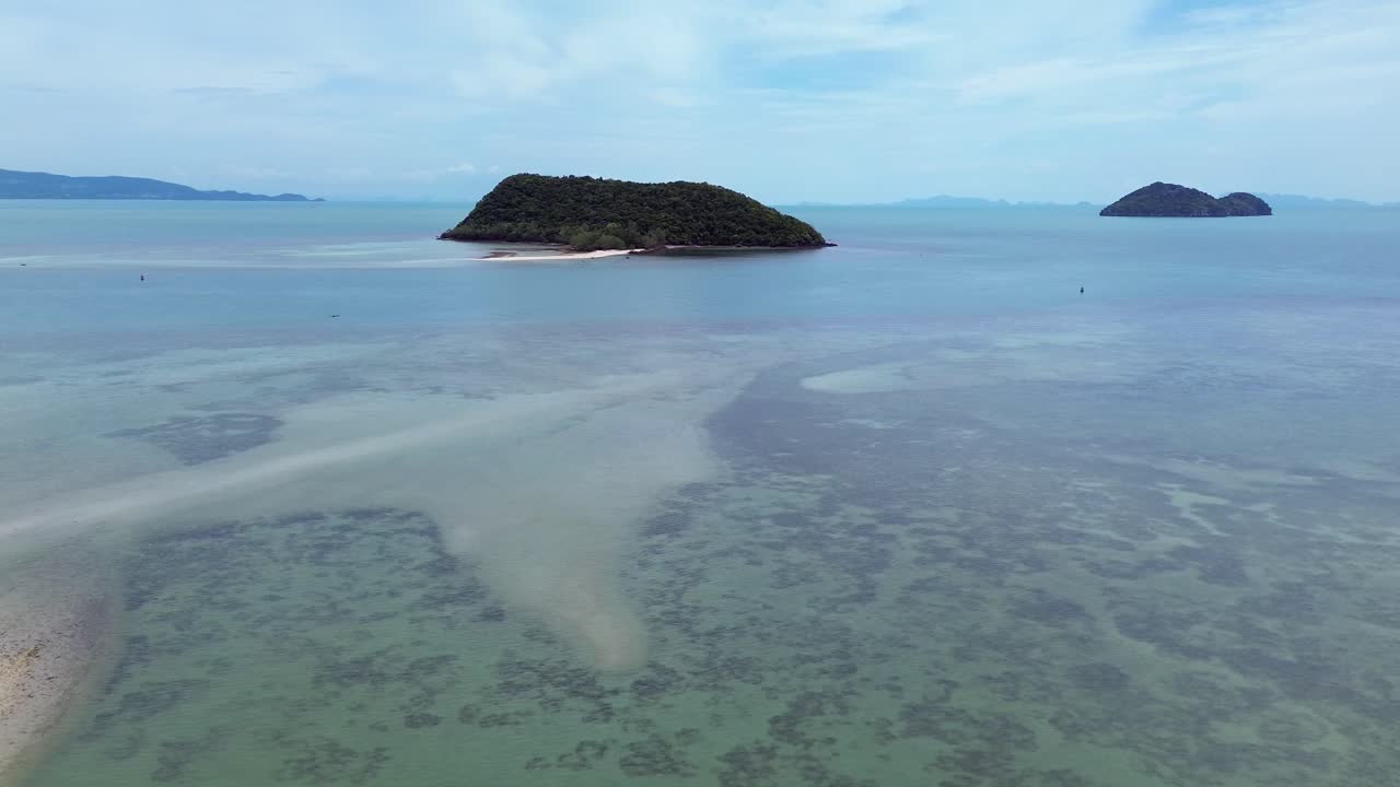 Aerial drone footage flying over Ko Tae Nai island near Koh Phangan, showcasing crystal clear waters, tropical coastline, and lush greenery