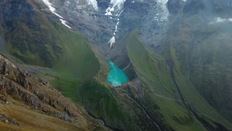 aéreo, día nublado, disparo de drone hacia el color esmeralda, lago humantay, la américa del sur, montañas de los andes, en peru, sudamerica