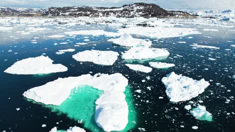 Frozen-massive-icebergs-float-near-coastline-of-Greenland,-aerial-view