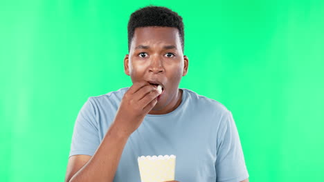 pantalla verde, cara y hombre negro comiendo palomitas de maíz