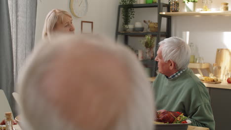 senior woman giving present to husband at birthday dinner