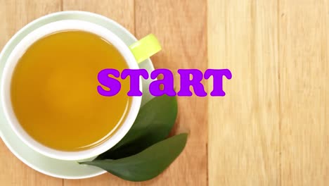 animation of start text over cup of tea on wooden background