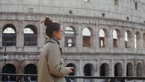 woman taking photo of the colosseum in rome