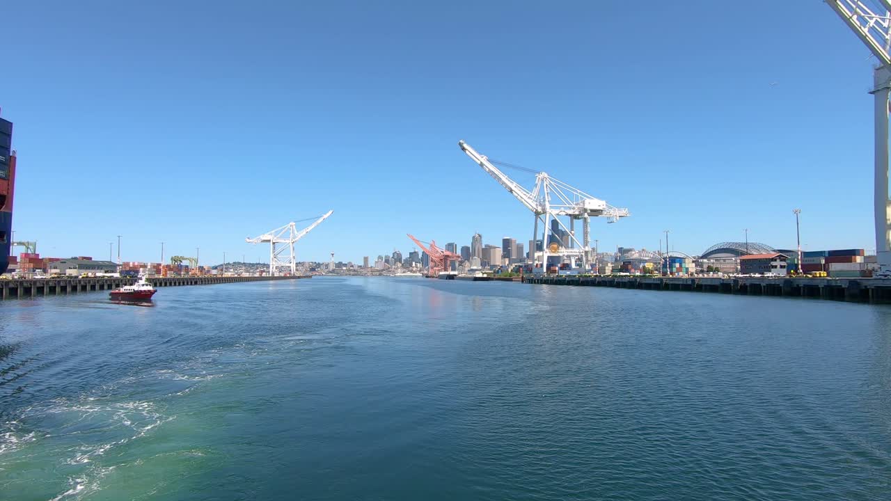 Sailing past piers in Seattle with huge cranes in background, slow motion