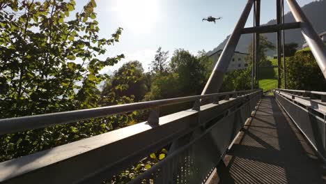 view of metal walking bridge, drone as it gracefully flies over the structure