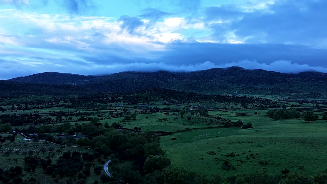 vuelo de avión no tripulado en el valle de tietar, las montañas con nubes colgando en las cumbres se pueden ver en el fondo, corren a alta velocidad a través del hiperlapso icono de validado por la comunidad