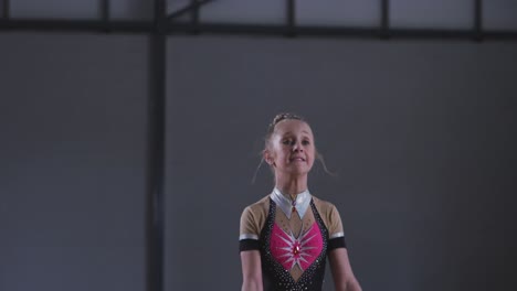 teenage female gymnast performing at sports hall