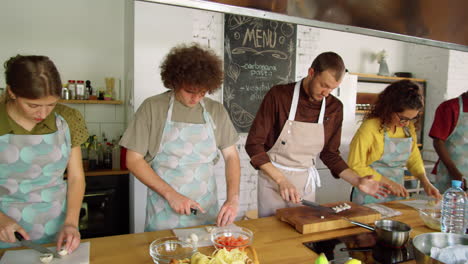 young people and chef cutting mushrooms at cooking master class