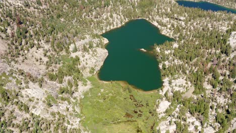 Aerial-of-Crystal-Lake-and-its-snowy-mountains-in-the-summer,-Mammoth-Lakes-in-4K