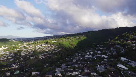imágenes de drones tomadas en la isla de oahu, hawai, de residencias ubicadas en la exuberante vegetación del barranco de la montaña cerca de kaawa mientras los pájaros pasan.