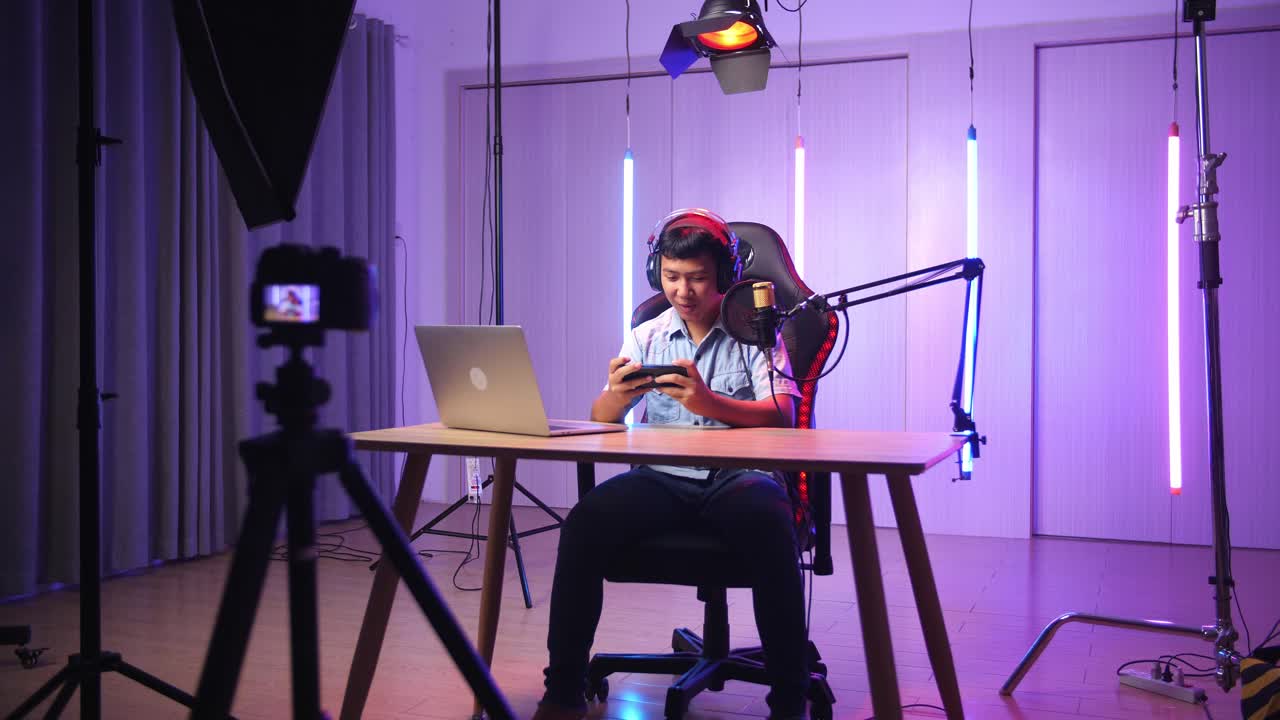 Excited Asian Kid Boy Playing Video Game With Mobile Phone While Live Stream, Professional Light Equipment