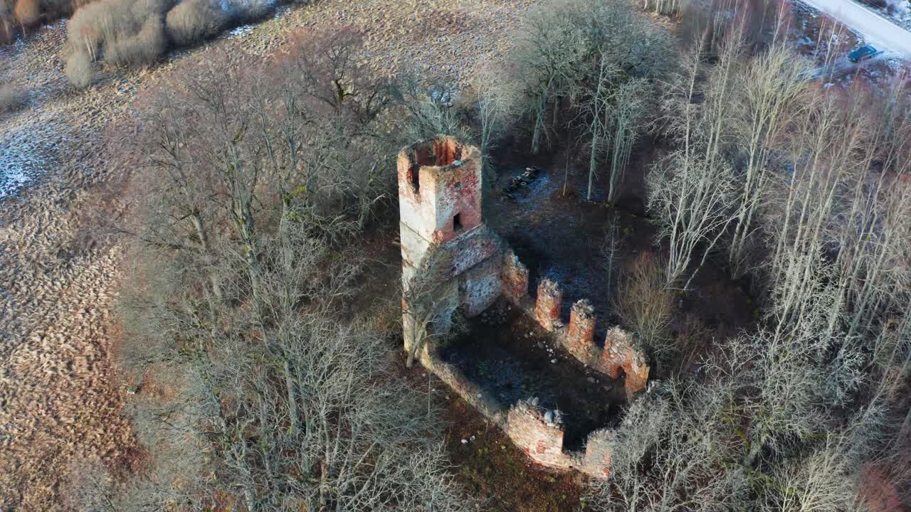 vista aérea de la antigua torre del campanario de la iglesia descuidada y los restos de la pared en el campo