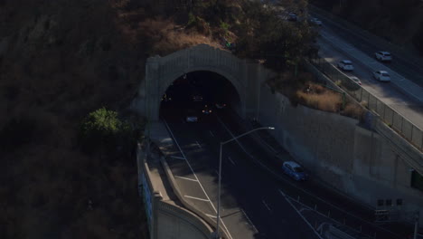 drone shot of los angeles traffic going on a bridge and out of a tunnel