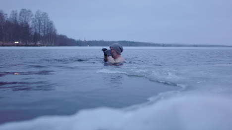 handheld shot of an ice bathing man in his late 50s swimming out