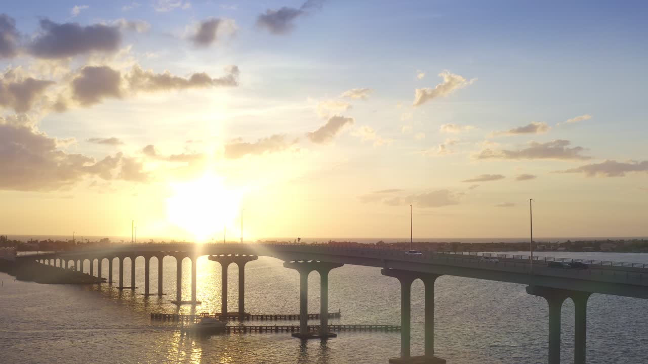 보트가 지나가는 석양에 다리에서 드론 4k 풀백