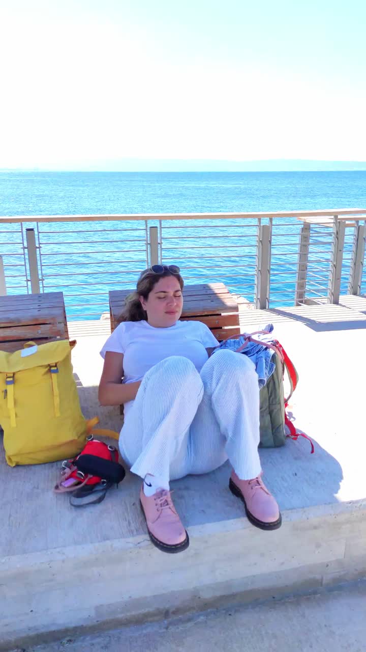 Young woman relaxing with eyes closed on the seaside promenade in Acre