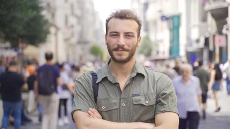 joven de pie en medio de la multitud mirando a la cámara.