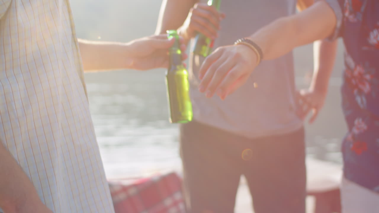 젊은 남자들이 bbq 파티에서 소시지를 고 맥주를 마시고 있습니다.