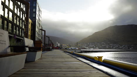 caminando por el paseo de madera en el muelle de la ciudad de tromso, noruega