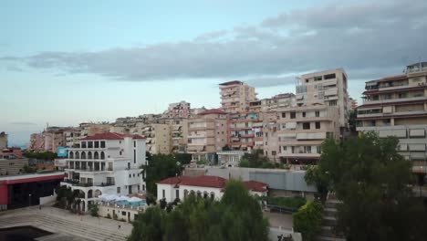 rising aerial shot over one of albania's coastal cities at dusk