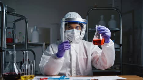 scientist in lab with face shield conducting research