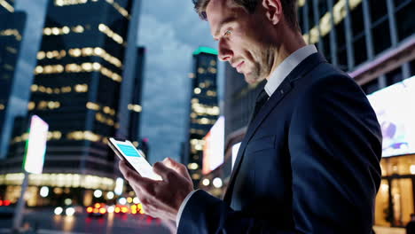 businessman using smartphone in a city at night
