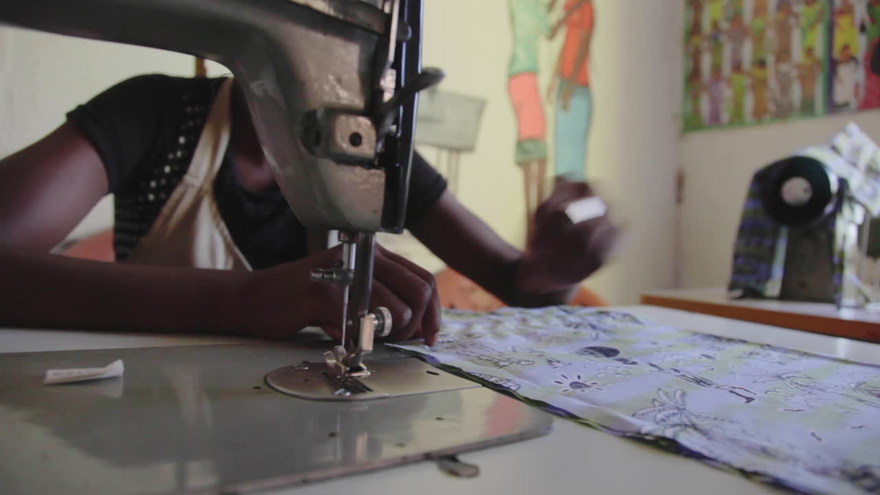 African local woman stitching clothes for a living