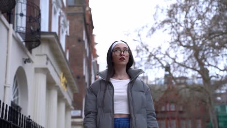 beautiful young woman walking in soho, london, low angle medium shot