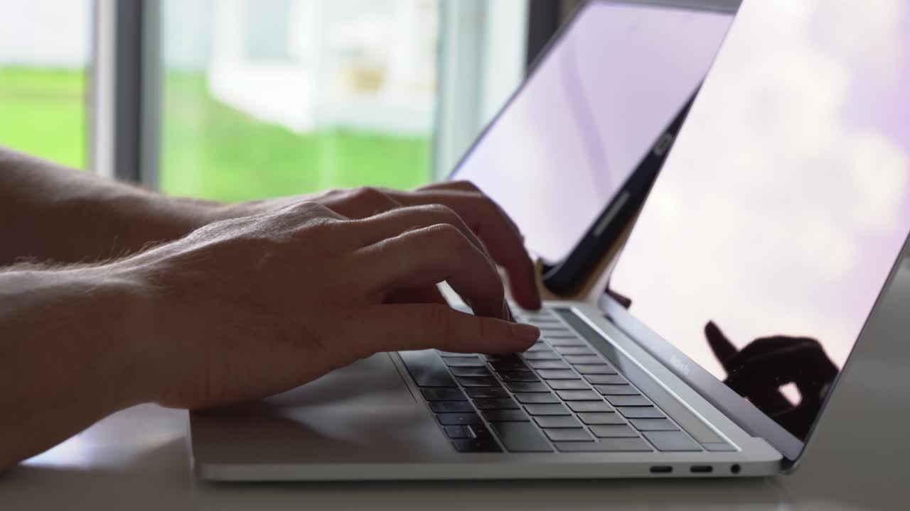 The concept of remote work. Close-up of male hands typing on the keyboard in search of information. A freelance copywriter is working on a project.