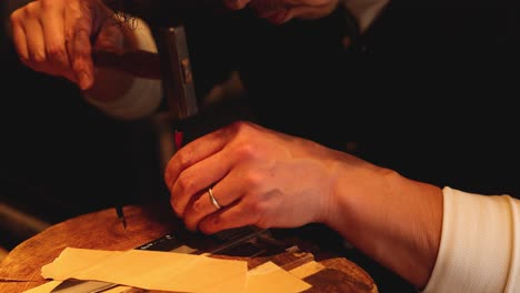 hands meticulously shaping wood with a chisel