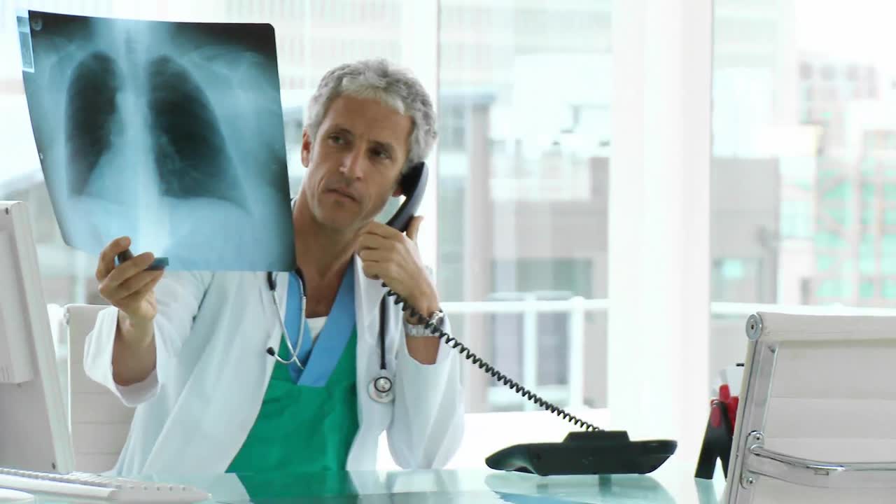 el médico en el teléfono mirando las radiografías.