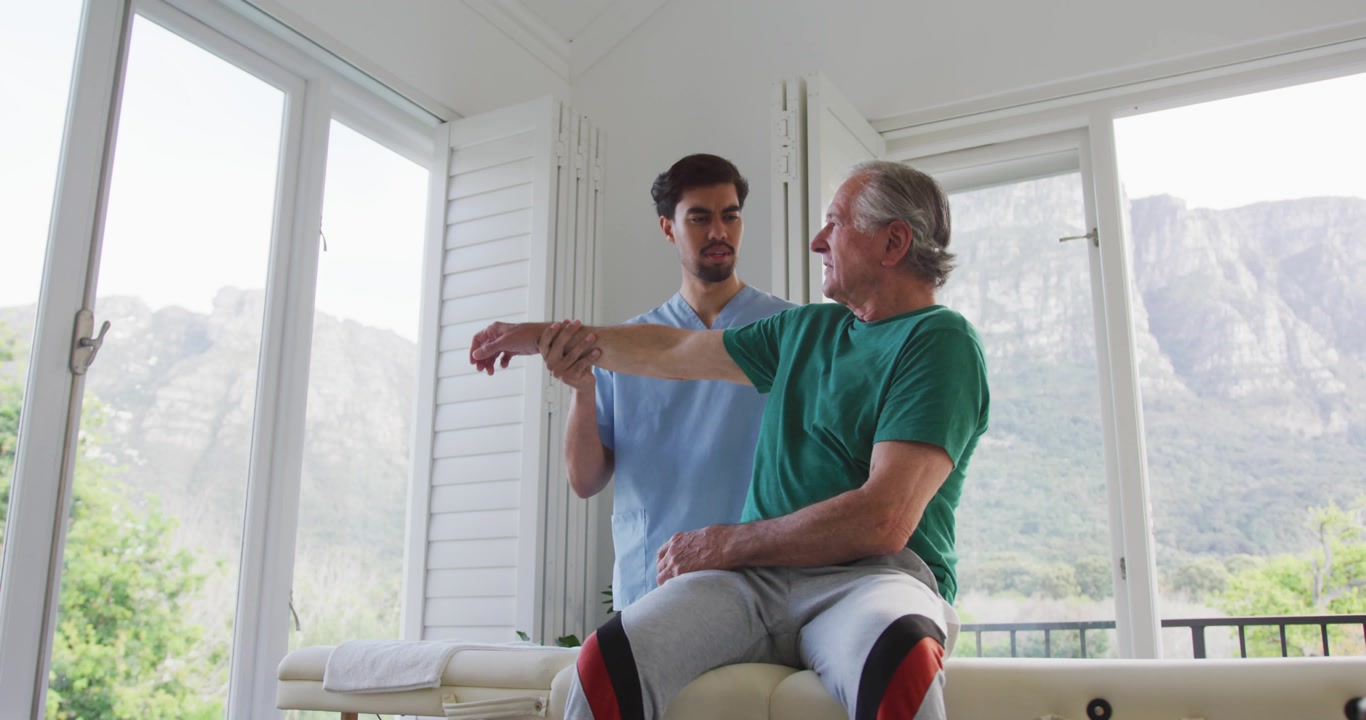 Therapist placing hands under patient arm, guiding through shoulder stretch with swirling numbers