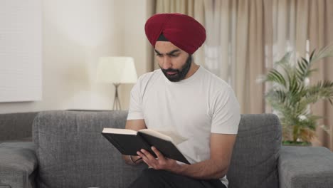 sikh indian man reading book and drinking tea