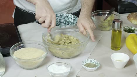 Chef-uses-round-spoon-to-scrape-and-press-together-fresh-mixed-vegetable-stock